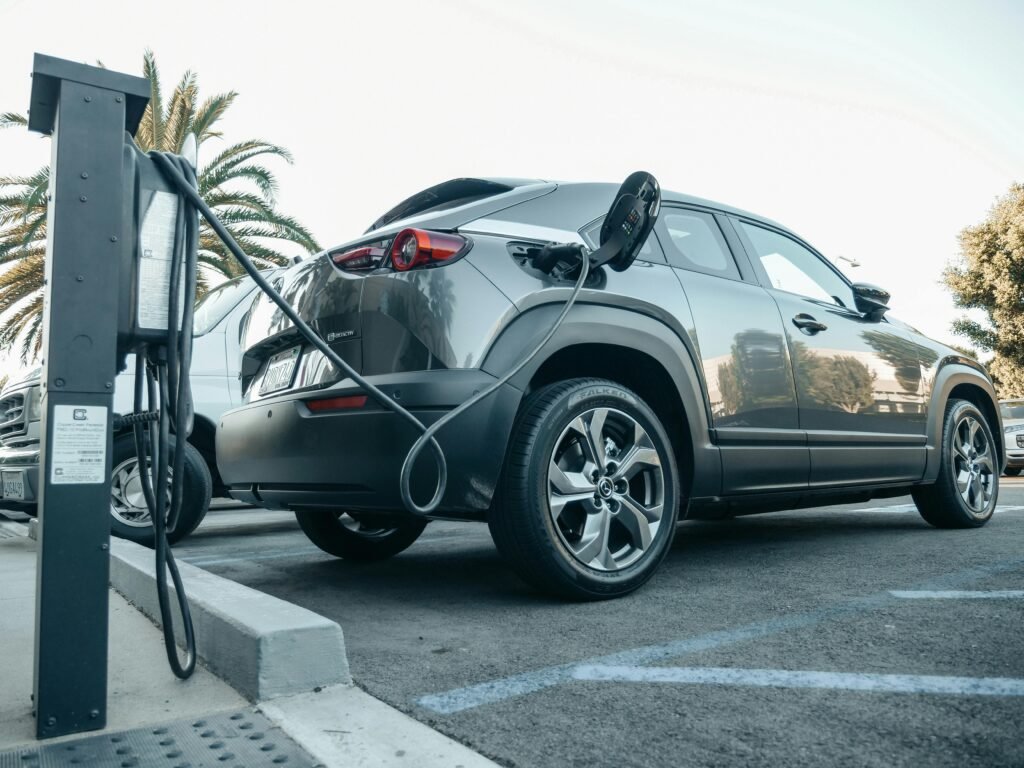 Modern electric vehicle charging at an outdoor station in daylight.